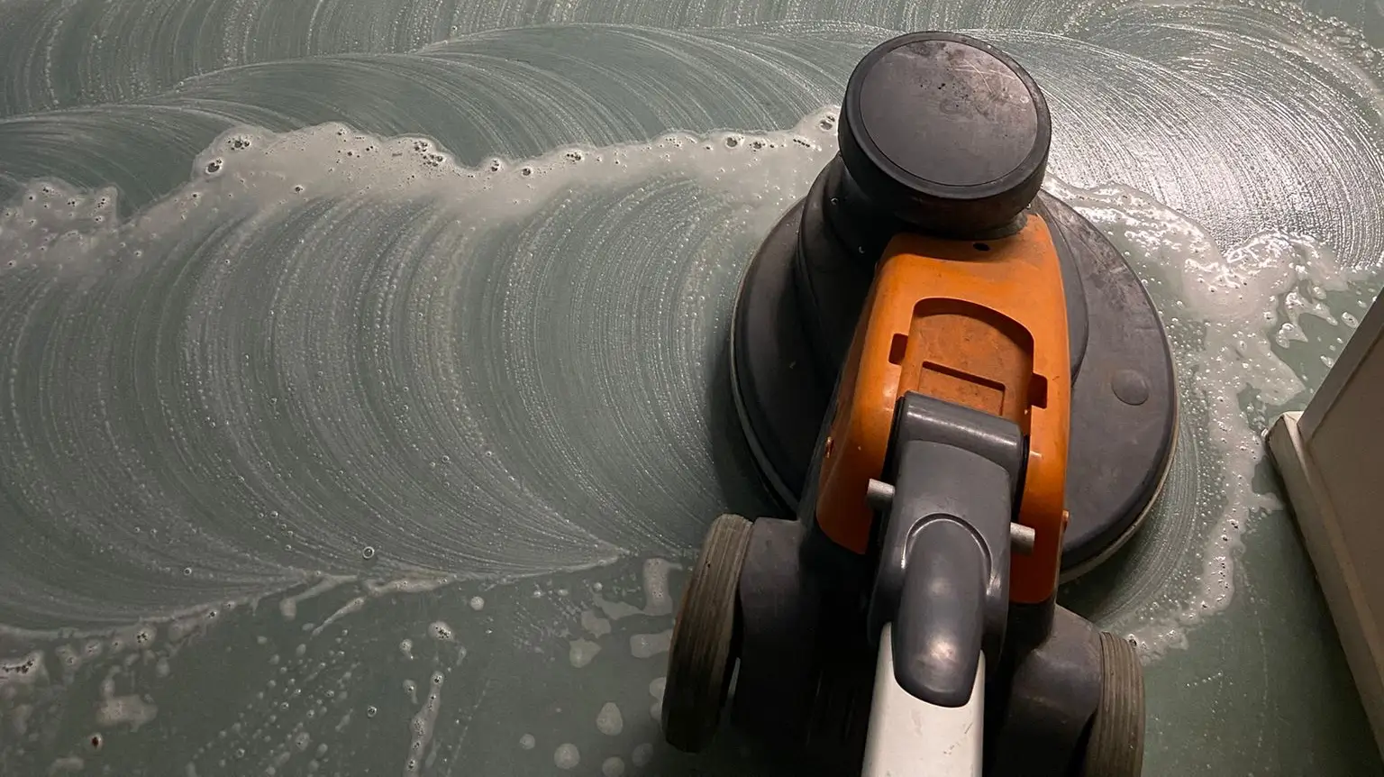 schijfmachine in actie om marmoleum te reinigen